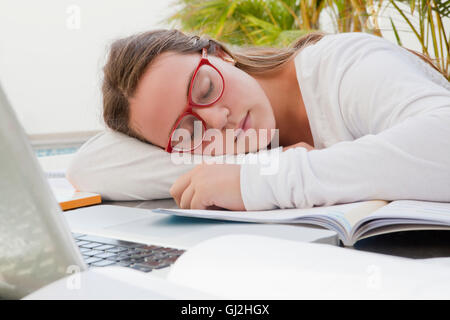 Teenage girl asleep on text books Stock Photo