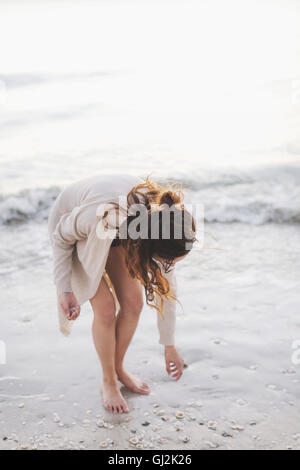 Woman picking seashells on beach Stock Photo