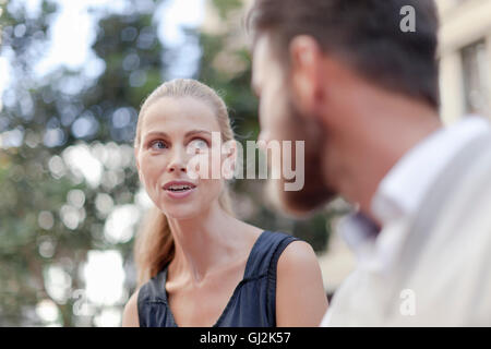 Mature man and woman sitting outdoors, having discussion Stock Photo