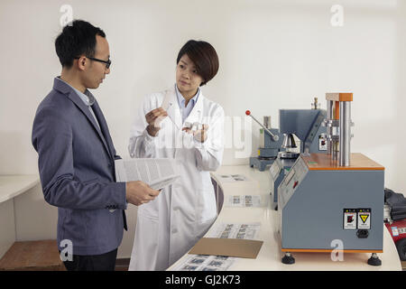 Technician explaining printing machine to manager in printing and packaging factory, China Stock Photo