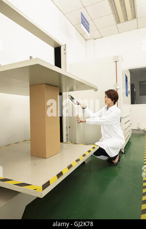 Female technician operating packaging machine in printing and packaging factory, China Stock Photo