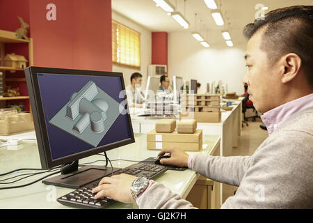 Male technician working on computer in printing and packaging factory, China Stock Photo
