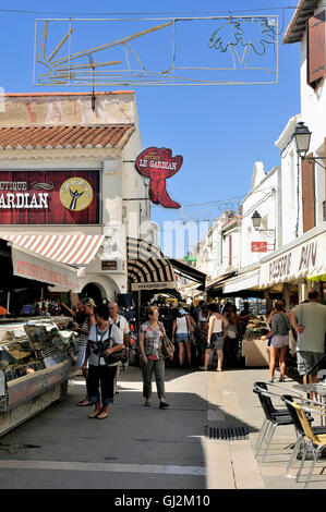 Walk through a pedestrian shopping street of Saintes-Maries-de-la-Mer in full summer. Stock Photo