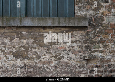 Distressed weathered brick wall detail in Bruges. Stock Photo