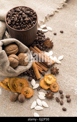 Coffee beans in a clay cup, next to nuts and dried fruits Stock Photo