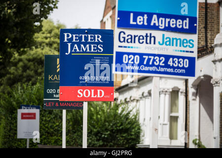 Estate agents boards advertising sale or rental seen outside London property, UK. Stock Photo