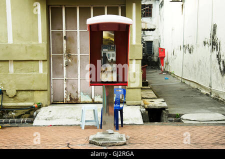 Old and dirty Public telephone or payphone booth malaysian style at George Town and street art area in Penang, Malaysia Stock Photo
