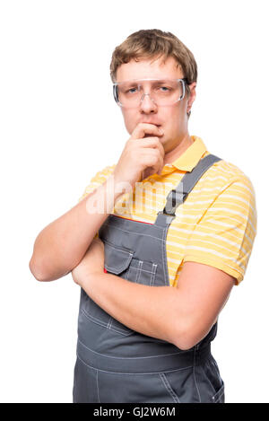 a man in overalls and protective glasses thinking on a white background Stock Photo