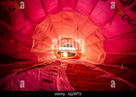 A view looking back through the crown (top) of a hot air balloon envelope during a burn as it inflates at Bristol International Balloon Fiesta, where unfavourable weather conditions have grounded the planned mass ascent and forced the pilots and crews to tether to the ground at Ashton Court Estate. Stock Photo
