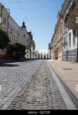 Old houses on a pedestrian street Olga Kobylianska in Chernivtsi, Ukraine. Cobbles on the road of the old town. Chernivtsi - an Stock Photo