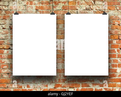 Close-up of two blank frames hanged by clips against orange brick wall background Stock Photo
