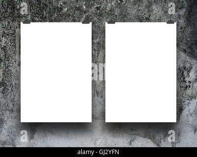 Close-up of two blank frames hanged by clips against gray weathered stone wall background Stock Photo