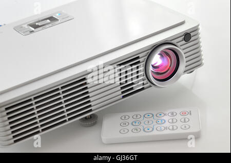 Portable led projector on white table Stock Photo