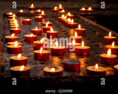 Prayer or Votive candles burning inside the church of Santa Maria della Salute, Venice, Italy. Stock Photo