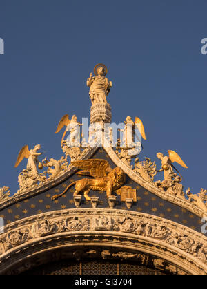 Detail of the gable showing St. Mark with angels. Underneath is a winged lion, the symbol of the saint and of Venice. Stock Photo
