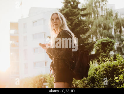 Young woman outdoors, using smartphone Stock Photo