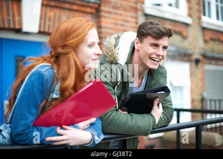 Young college student couple leaning against campus handrail Stock Photo