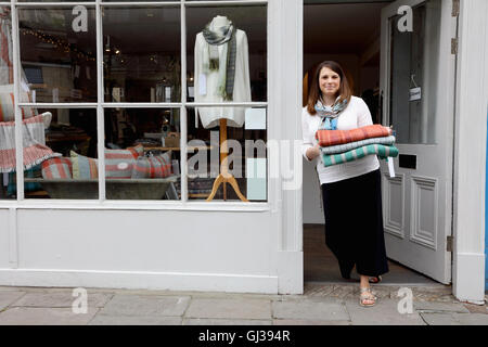 Shop owner in doorway holding fabric Stock Photo