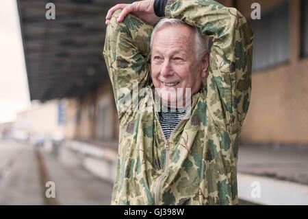 Man with hands behind head stretching looking away smiling Stock Photo