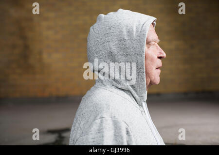 Side view of man wearing hooded top looking away Stock Photo