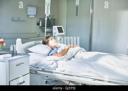 Woman laying down in hospital bed Stock Photo