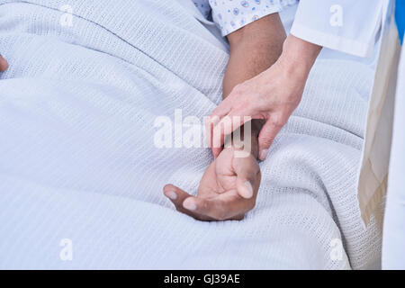 Cropped view of doctors hand taking patients pulse Stock Photo