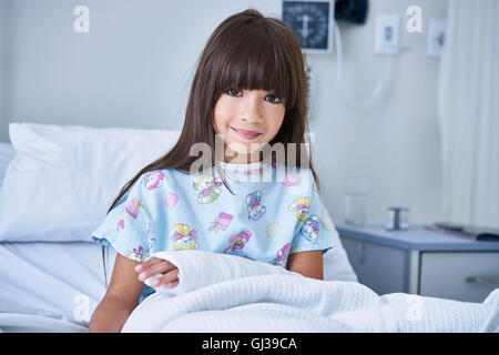 Portrait of girl patient with arm plaster cast in hospital children's ward Stock Photo