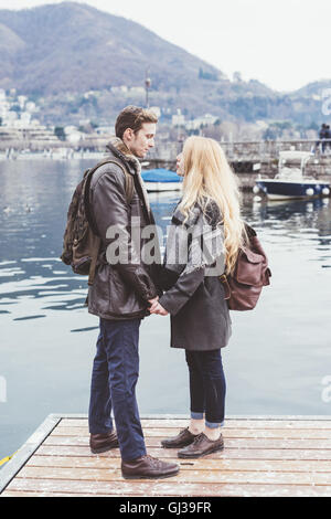Romantic young couple gazing at each other on pier, Lake Como, Italy Stock Photo