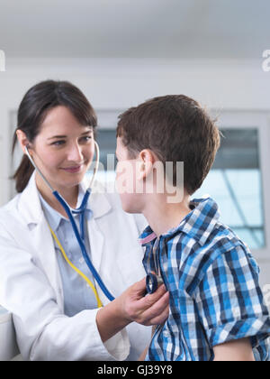 Doctor checking boy's breathing with stethoscope Stock Photo