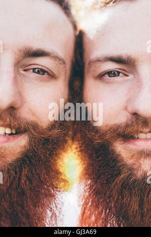 Cropped close up portrait of young male hipster twins with red beards Stock Photo