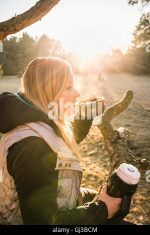 Woman relaxing and having coffee on treetop, Augsburg, Bavaria, Germany Stock Photo