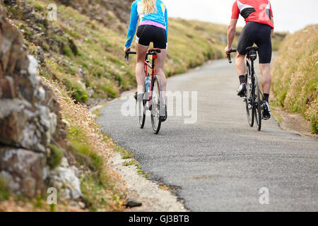 Cyclists riding on country road Stock Photo