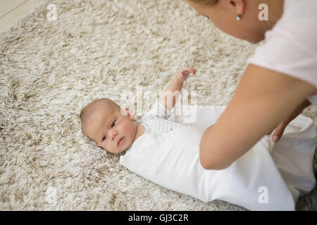 Swaddling Step 4. Mother wrapping baby boy with blanket Stock Photo