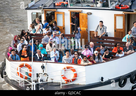 LONDON, UK - 18TH JULY 2016: A boat on the River Thames in London. Lots of people can be seen on the boat. Stock Photo