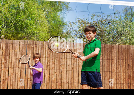 Sportive kid boy hitting forehand in tennis Stock Photo