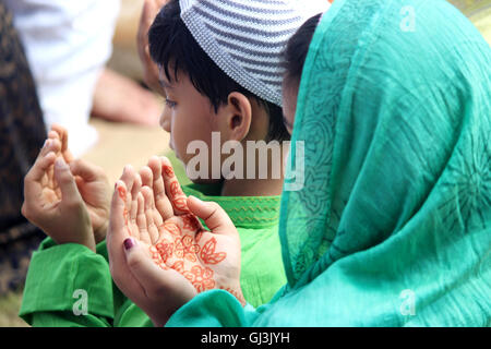 Brother and sister are praying. Young Muslim girl and boy are praying for god during Idd festival. Stock Photo