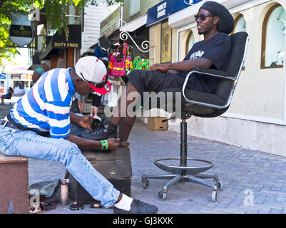 dh Philipsburg West Indies ST MAARTEN CARIBBEAN Man getting boots polished by shoeshine boy polishing shoes shined