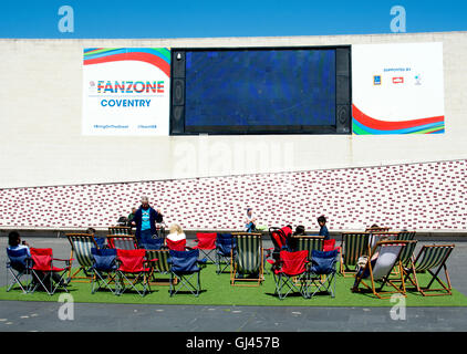 Coventry, UK. 12th August, 2016. UK Weather. People enjoy the warm sunny weather whilst watching the big screen in the Rio Olympics Fanzone in Millennium Place in Coventry city centre. Credit:  Colin Underhill/Alamy Live News Stock Photo