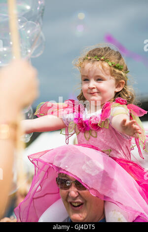 Burley, Hampshire, UK. 13th Aug, 2016. Young girl dressed as fairy sitting on shoulders catching bubbles at the New Forest Fairy Festival, Burley, Hampshire, UK in August  Credit:  Carolyn Jenkins/Alamy Live News Stock Photo