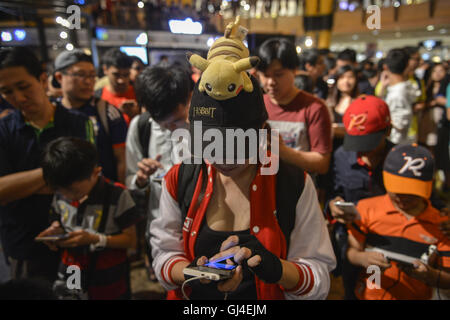 Sunway, Selangor, Malaysia. 13th Aug, 2016. People play 'Pokemon Go' on their smartphones during Pokemon Costume Contest at Sunway Pyramid Shopping Mall outside Kuala Lumpur. Players use a mobile device's GPS capability to locate, capture, battle, and train virtual creatures, called Pokémon, who appear on the screen as if they were in the same real-world location as the player. Credit:  Kepy/ZUMA Wire/Alamy Live News Stock Photo