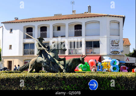 Statue of Guardian guiding a bull on the roundabout to the city center Camarguaise city of Saintes-Maries-de-la-Mer. Stock Photo