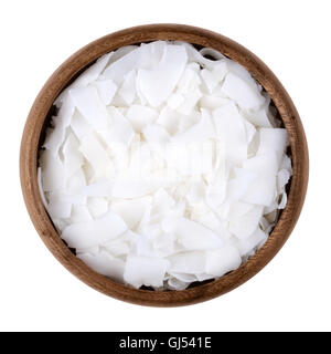 Coconut flakes in a bowl on white background, also called copra. Dried and grated flesh or meat of the coconut kernel. Stock Photo