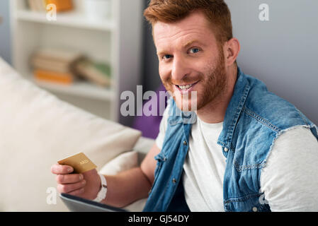 Cheerful man sitting on the sofa Stock Photo