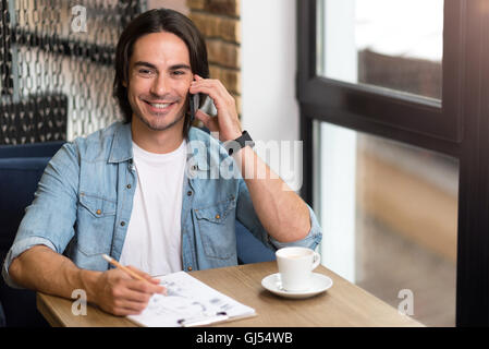 Cheerful man sitting at the table Stock Photo
