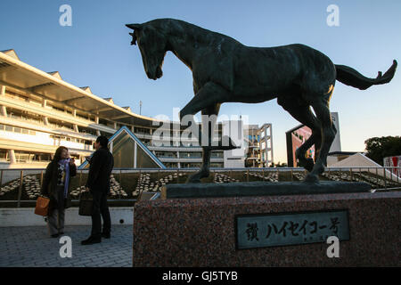 Couple at the statue of top horse 'Haiseiko' who won many of the best races in the early seventies and went on to sire many winn Stock Photo