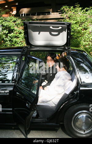 The, bride and groom,at, bride,entering,a,special,wedding,taxi,car,with,roof,opening,for,costume,a traditional Japanese Shinto,wedding,ceremony,Tokyo, Stock Photo