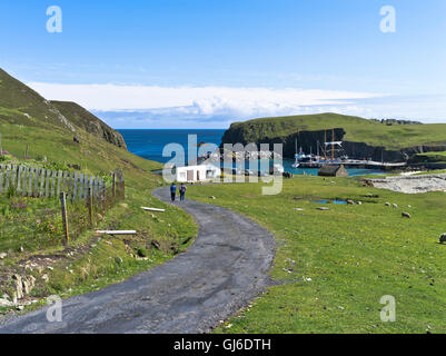 dh  FAIR ISLE SHETLAND Couple walking road to North Haven harbour  pier