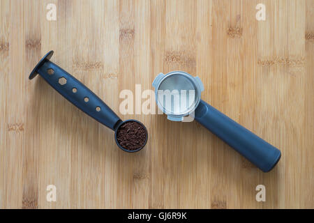 Coffee grounds in a scoop and filter holder of an espresso machine. Stock Photo