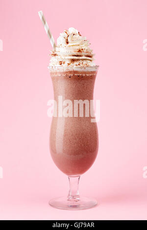 Glass of cold chocolate milkshake with whipped cream on pink background Stock Photo