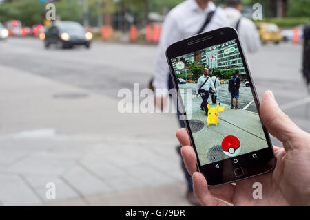 Montreal, CA - August 12, 2016: Closeup of a man playing Pokemon Go on a smart phone. Stock Photo